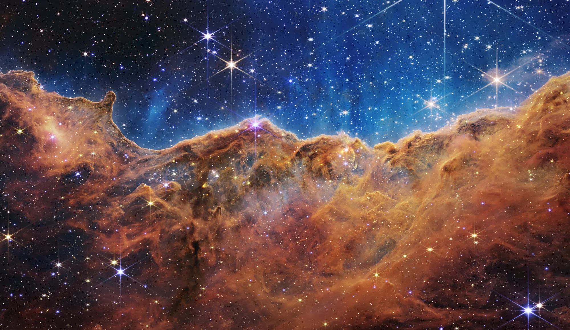 Webb telescope view of stars and golden gas clouds in the Carina Nebula